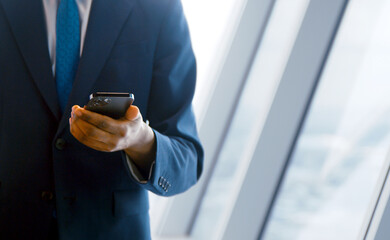 Young businessman in a suit using a smartphone close up - 492732460