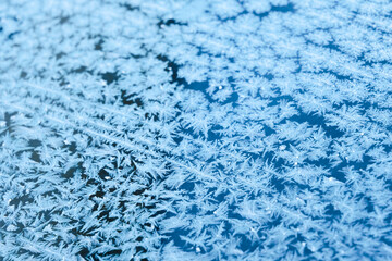 Structure and texture of ice lenses, frozen snowflakes. Frost and cold. Cold gamma. Selective focus. Winter season and frost. Sub-zero temperature. Close-up. First snow.