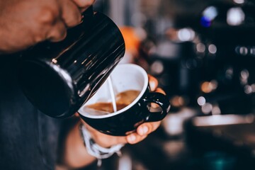 Barista making coffee with coffee machine in cafe.