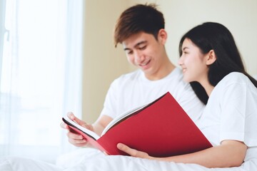 Obraz premium asian couples planning for future looking books, buying life insurance, buying houses, looking at wedding photos.