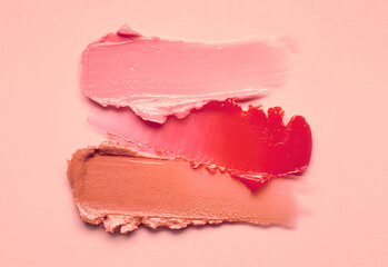 Lipstick burgundy peach orange brown balm lip gloss swatch isolated on beige background - obrazy, fototapety, plakaty