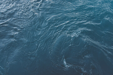 Blue sea surface with waves and ripples. Top view