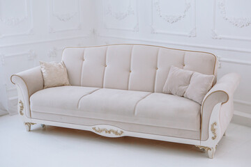 A white sofa standing in a bright photo studio