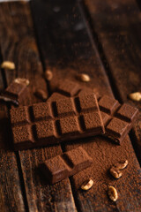 Bar of chocolate on a dark background. Cocoa and nuts.