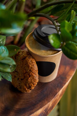 Takeaway coffee in a paper cup and delicious cookies. Close-up. Selective focus. Soft blurred background. Top view.