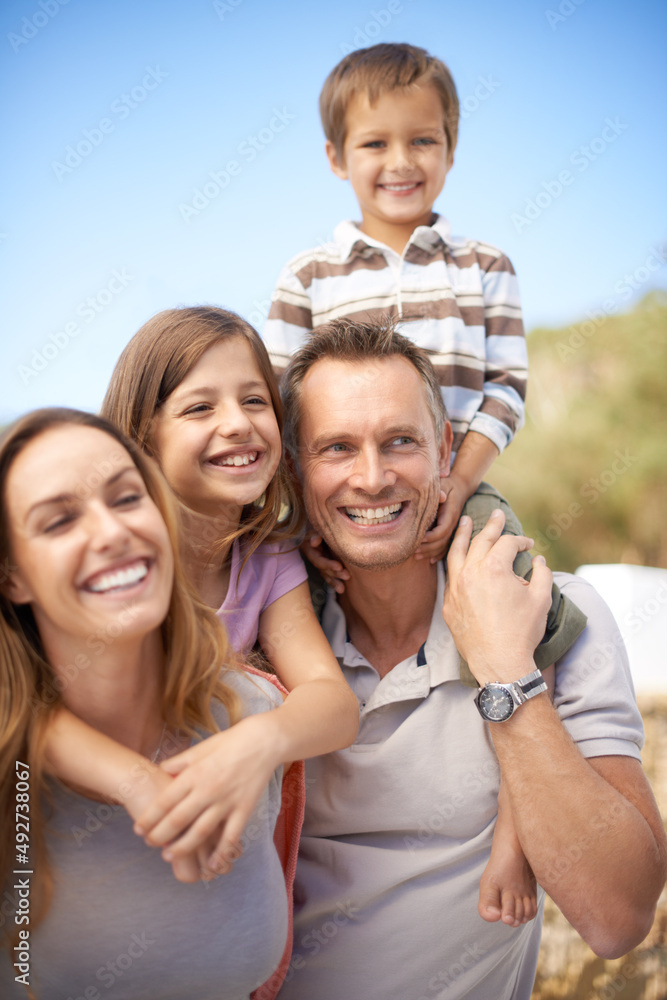 Wall mural One awesome family adventure. Portrait of a happy family of four having fun while on holiday.