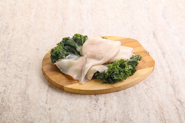 Raw squid over wooden board