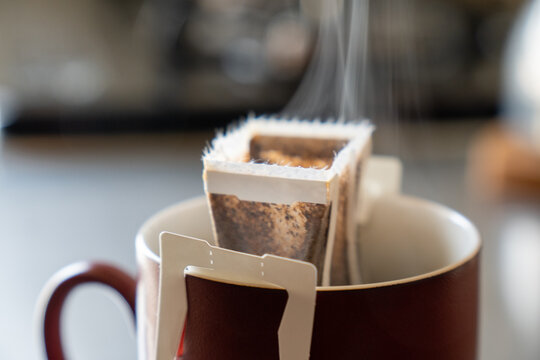 湯気が立つドリップパックコーヒー（赤コーヒーカップ）