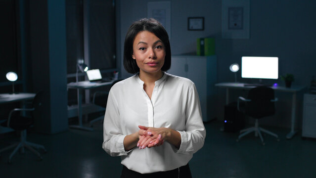 Portrait of African-American businesswoman look at camera and speak standing in dark office
