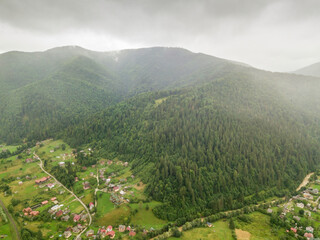 Settlement in the mountains of the Ukrainian Carpathians. Aerial drone view.