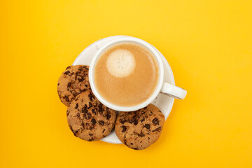 a cup of coffee with cookies chocolate drops