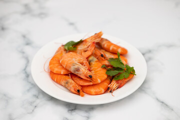 boiled fresh shrimps with parsley on white small dish