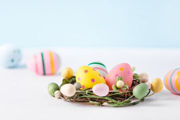 Multi coloured easter eggs in nest on white background. Happy Easter greeting card. Easter background.