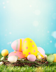 Multi coloured easter eggs in nest on meadow. Happy Easter greeting card.