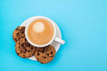 a cup of coffee with cookies chocolate drops
