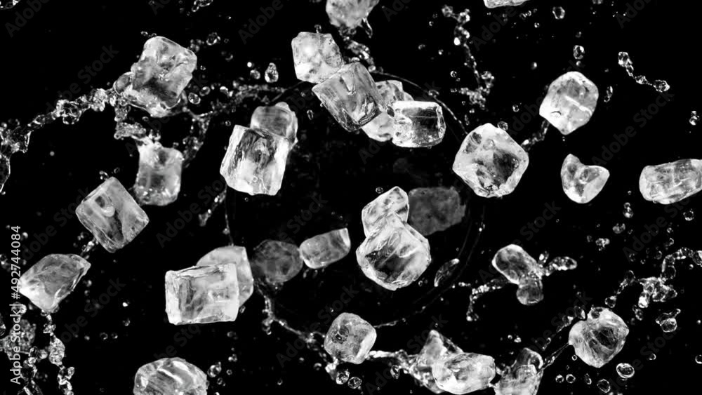 Aufkleber Super slow motion of rotating ice cubes with splashing water, top view shot. Filmed on high speed cinema camera, 1000 fps. Isolated on black background. Speed ramp effect.