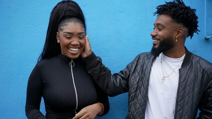 Candid two adult siblings teasing each other outside brother and sister laugh and smile