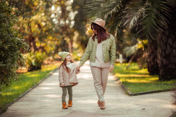 Fototapeta premium red-haired mother and daughter are walking in the park. family leisure in the city