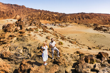 Obraz na płótnie Canvas A couple in love stands in the crater of the Teide volcano. Desert landscape in Tenerife. Teide National Park. Tenerife, Spain