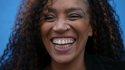 A happy diverse latin person in 40s laughing and smiling on blue background