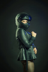 A woman wearing a motorcycle helmet on a dark background. The concept of space.