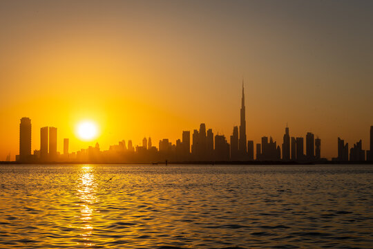 Dubai Downtown skyline during sunset seen from Dubai Creek Harbour promenade.