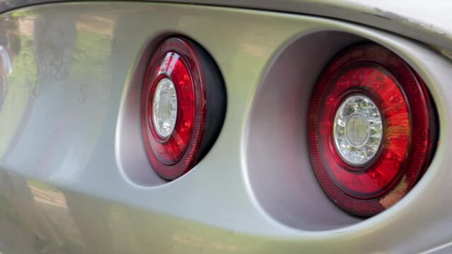 Large, red, round taillights of a racing modern sports car.