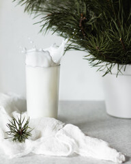 Milk spilling from glass on 
white table.