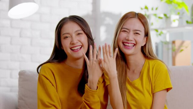 An Asian lesbian couple is wearing wedding rings. They spend time together as a normal couples and LGBT conceptual are. They are perfect together and a lots of happiness.Good moment looking at camera