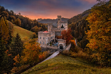 Latzfons, Italy - Beautiful autumn scenery at Gernstein Castle (Castello di Gernstein, Schloss Gernstein) at sunrise in South Tyrol with colorful sky and golden foliage with Dolomites at background