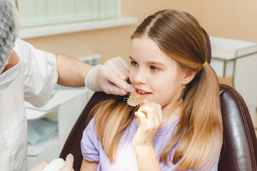 Dental plate. Expansion of the jaw in a child. teenage girl holding an orthodontic plate in her...