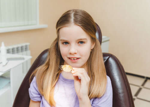Dental plate. Expansion of the jaw in a child. teenage girl holding an orthodontic plate in her hands
