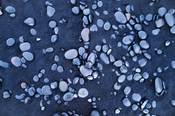 Gray pebbles as a background. Round stones on the beach. Photography for design. Textures in nature.