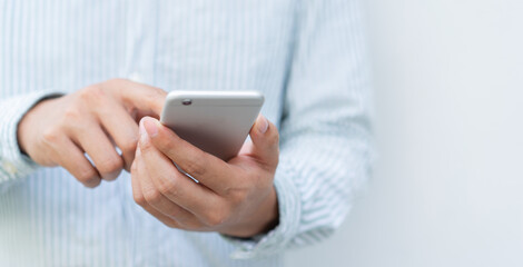 close up man hold smartphone to use by surfing the internet or read news on website or social media...