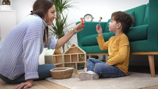 Educational Therapist playing game with little child with wooden toy to help him to improve his behavior and mental health