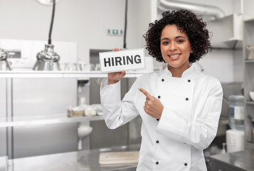 job, work and employment concept - happy smiling female chef in white jacket holding hiring sign...