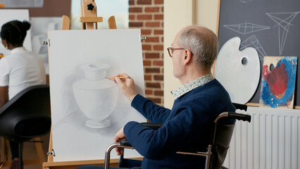 Elder person in wheelchair creating vase drawing on canvas, attending artistic workshop to develop...