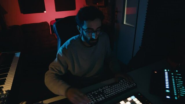 Dj producer guy with eyeglasses is mixing a voice of a song in the studi