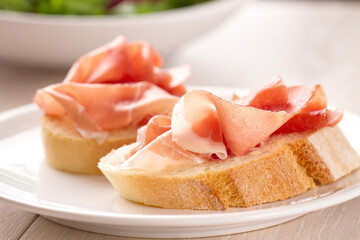 Italian appetizer bruschetta with Parma ham on a plate