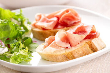 Italian appetizer bruschetta with Parma ham on a plate