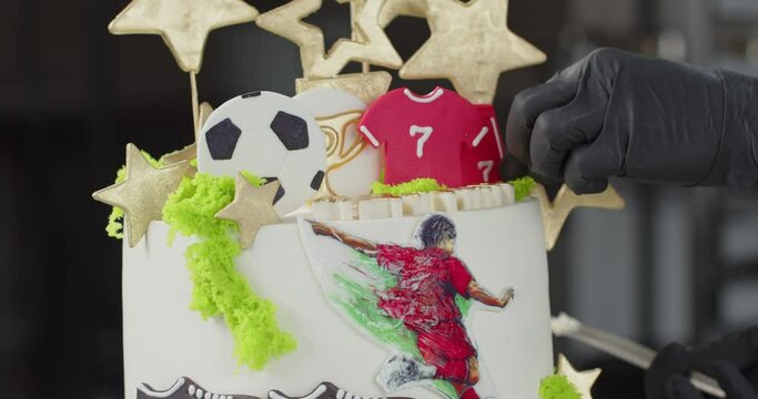 Professional confectioner decorates the holiday cake with various sweet elements