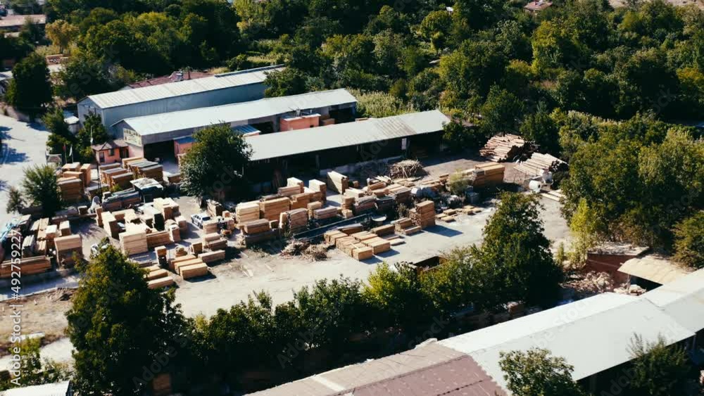Poster drone view of a large logging factory with a tin-roofed processing facility. warehouse and timber pr