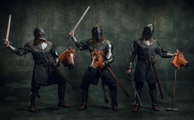 Collage. Portrait of medieval warrior or knight wearing helmet and armor riding toy horse, holding big sword isolated over dark background. Comparison of eras, history