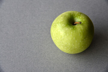 A green apple on a gray background