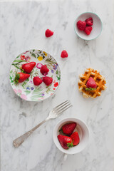 Vintage breakfast with waffles and red berries on white background