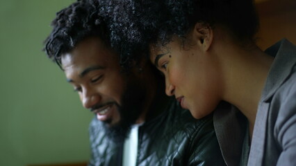 A black couple laughing and smiling in conversation candid and casual