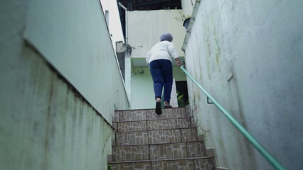 Obraz na płótnie Canvas older woman going up the stairs at home arriving house