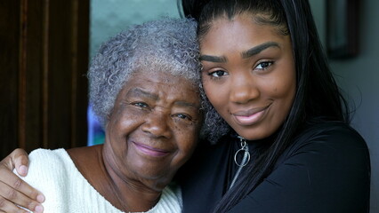 A teen granddaughter embracing grandmother a black girl embraces grandparent - obrazy, fototapety, plakaty