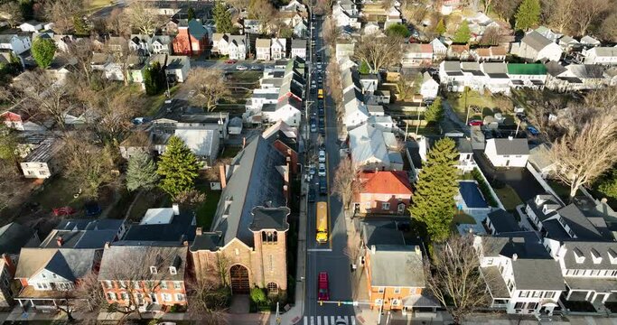 Traffic in small town USA. Yellow school, cars, vehicles on street in winter morning commute. Aerial view.