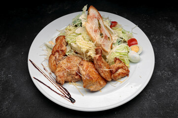 Chicken breast with salad, eggs, on a black background with space for text